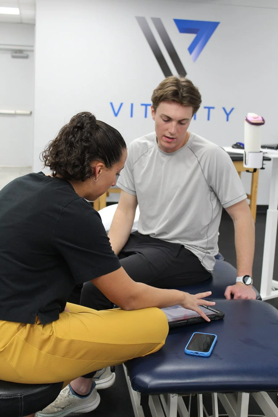 A patient working through low back and core strength exercises with a Vitality coach