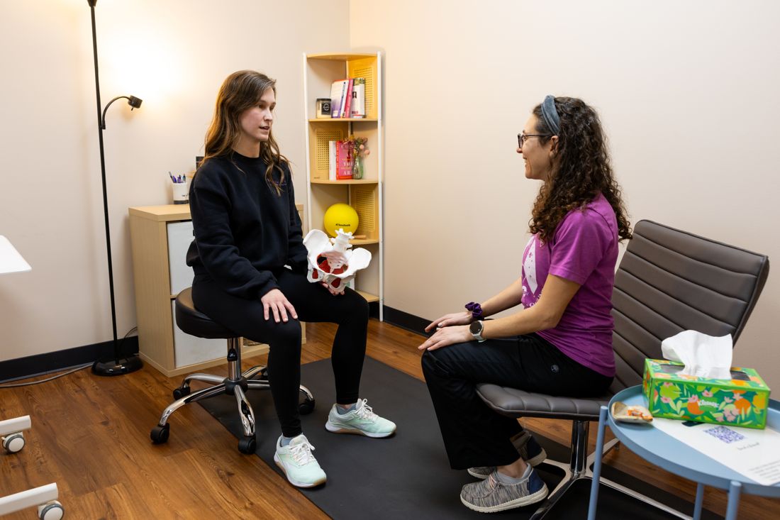 Vitality Pelvic Health therapist reviewing a pelvic anatomy model with a patient during consult