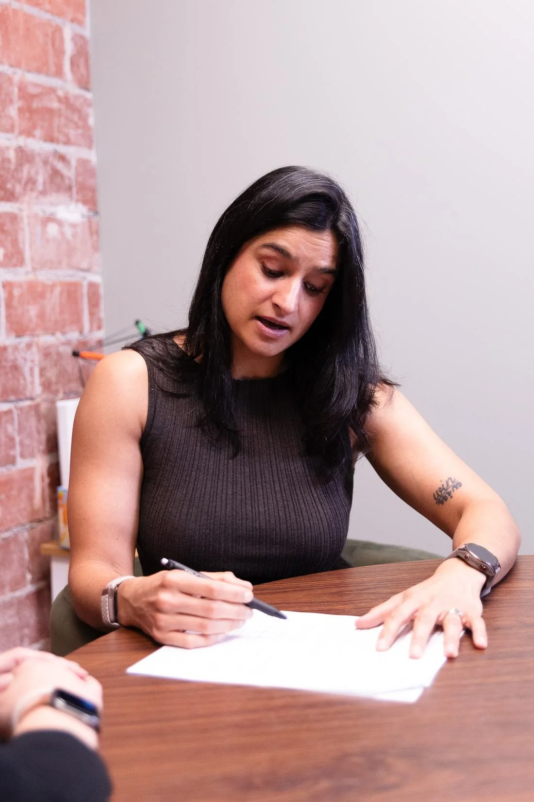 Dr. Amrit Dockery taking detailed notes during a consultation