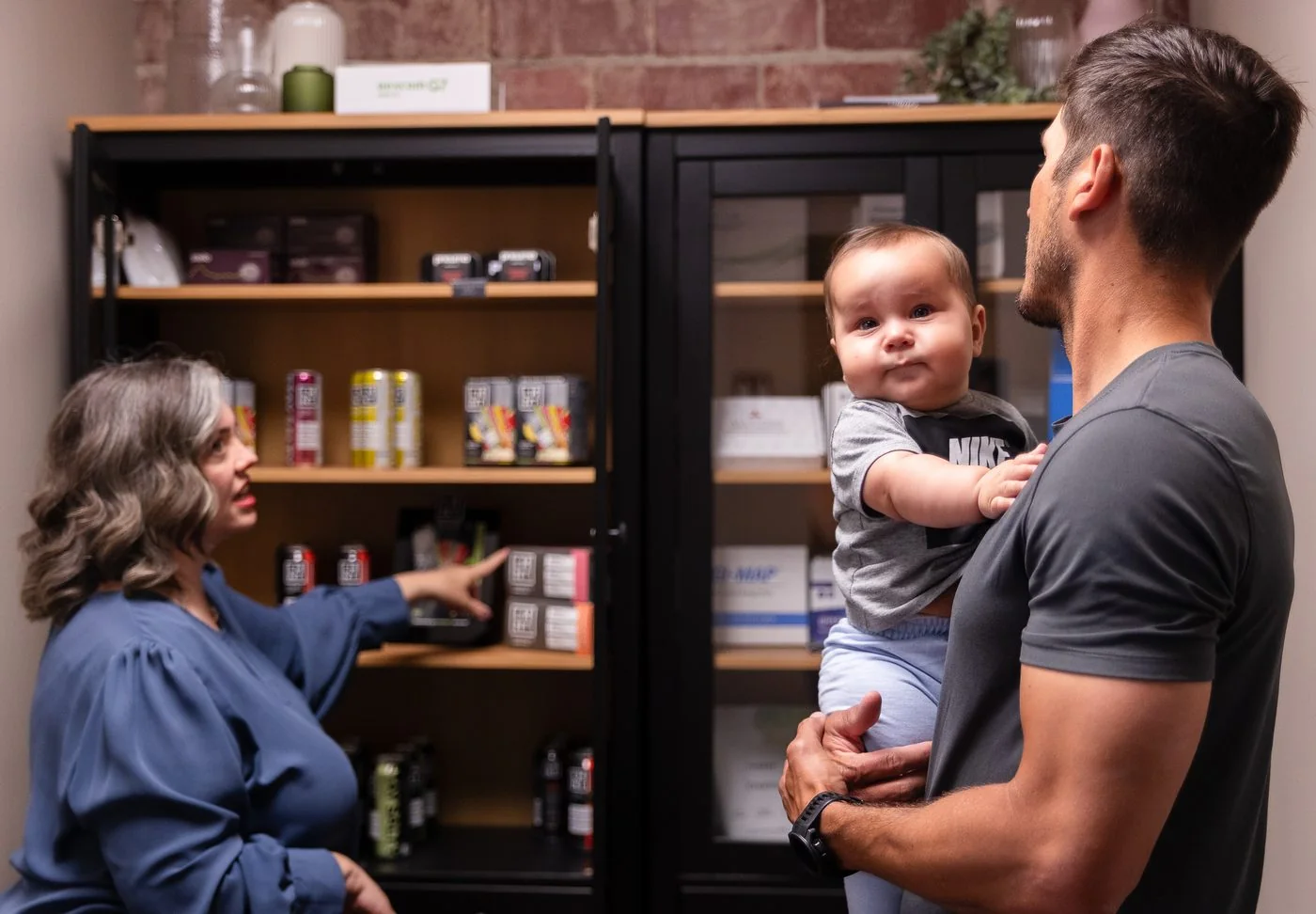Vitality Functional Family Medicine team member with a patient family at the supplement bar