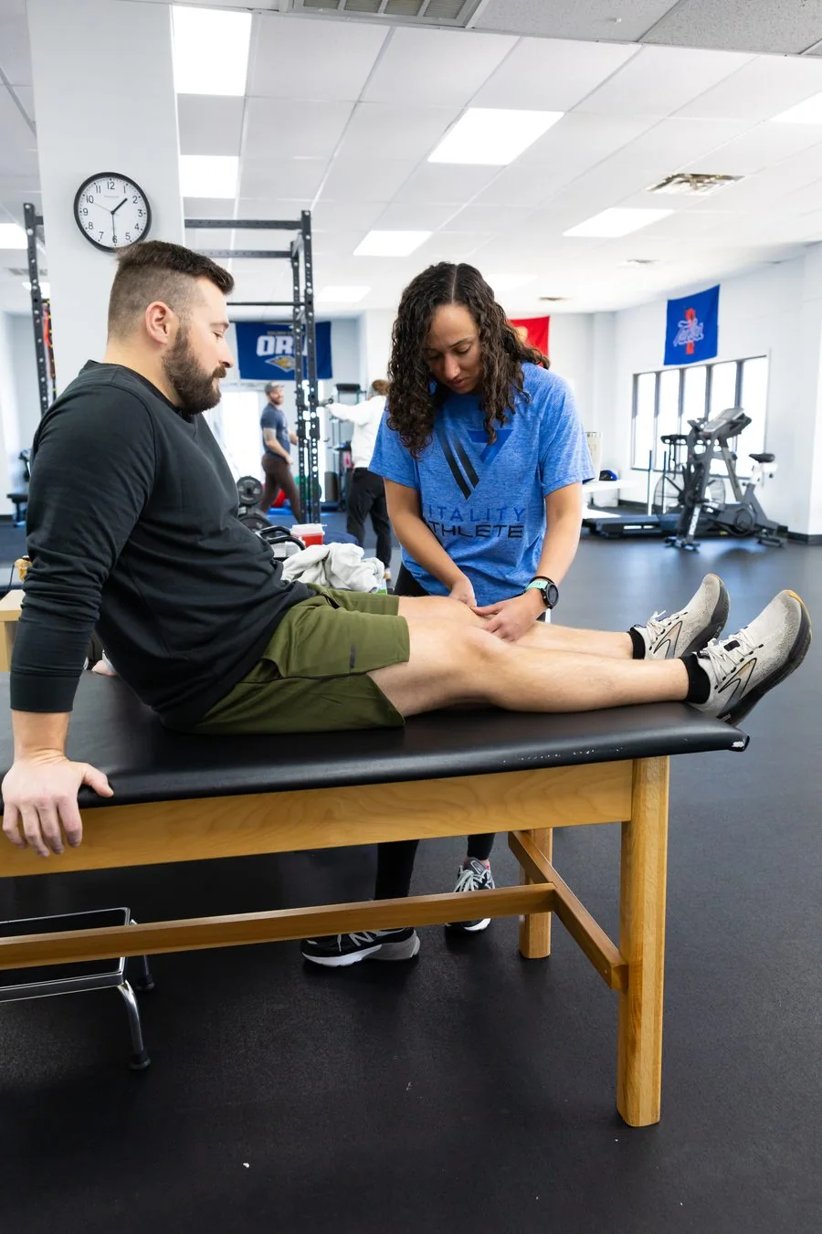 A patient doing a deadlift or hip-hinge exercise at Vitality Therapy and Performance
