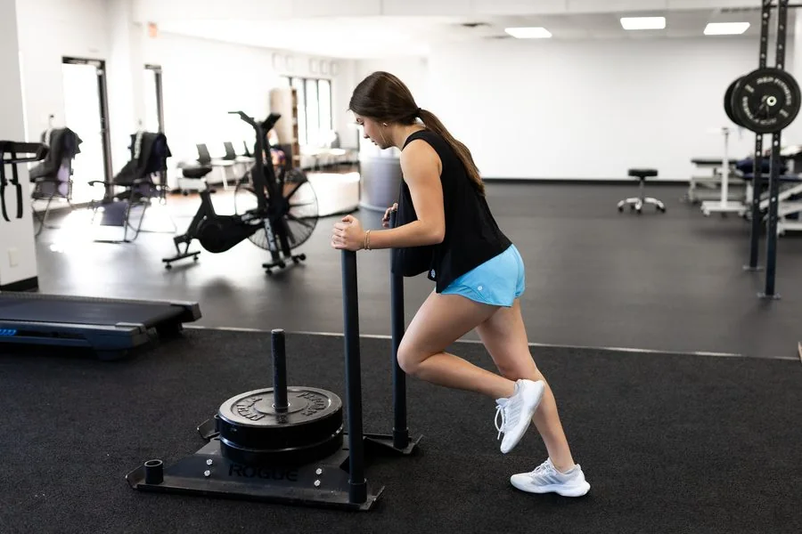 A patient doing a deadlift or hip-hinge exercise at Vitality Therapy and Performance