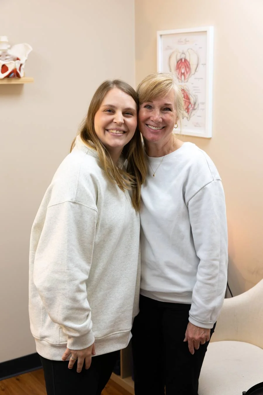 A smiling patient with her Vitality pelvic health physical therapist in a treatment room