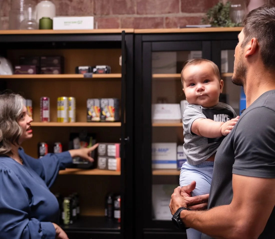 Vitality Functional Family Medicine team member with a patient family at the supplement bar