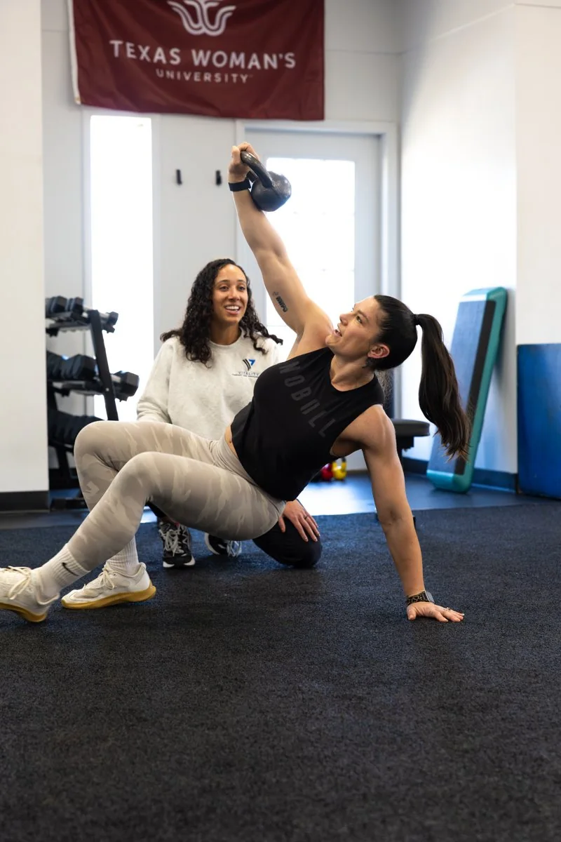 Coaching a kettlebell single-arm get-up at Vitality Therapy and Performance